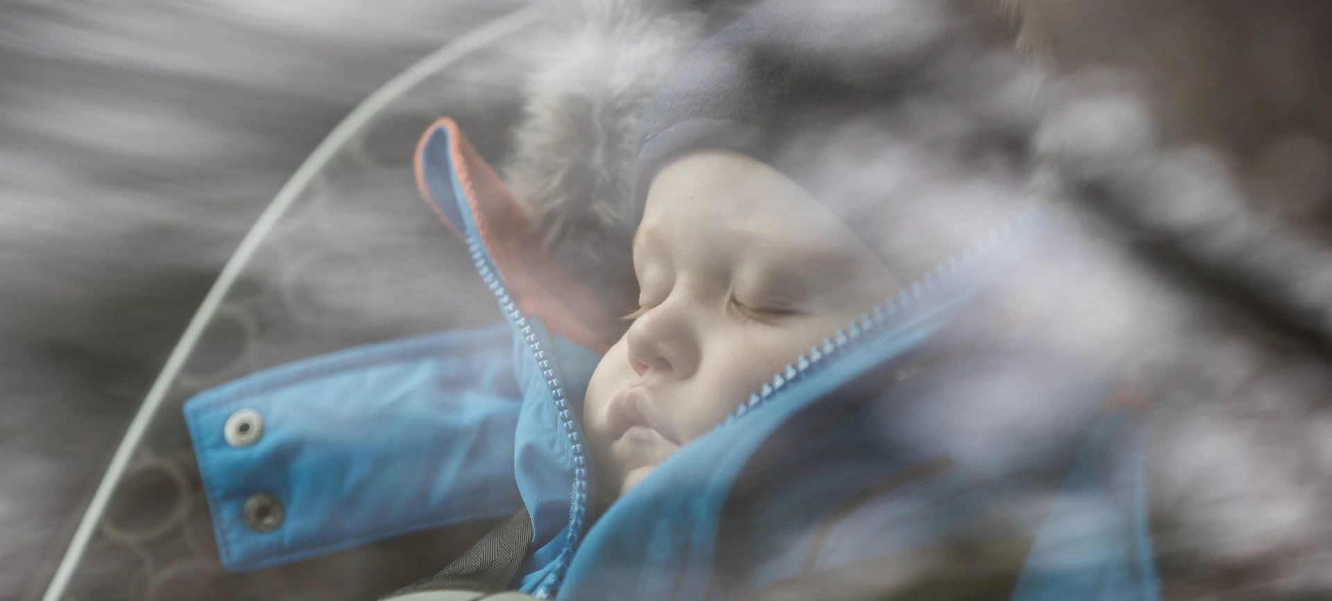 A child sleeps deeply in a car, thanks to sound insulation glass reducing outside noise and enhancing comfort.