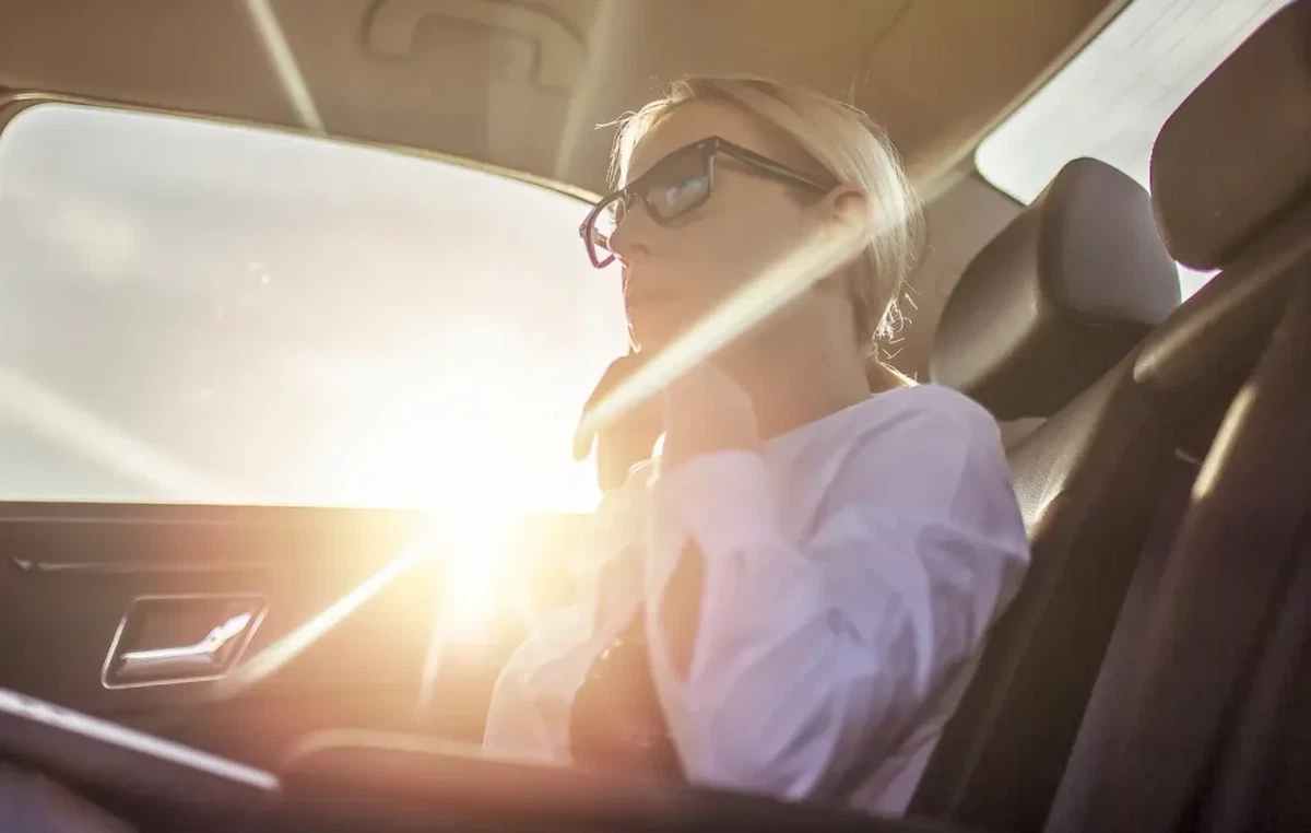 A woman near the glass that transmits the visible light and blocks near-infrared rays and UV lights